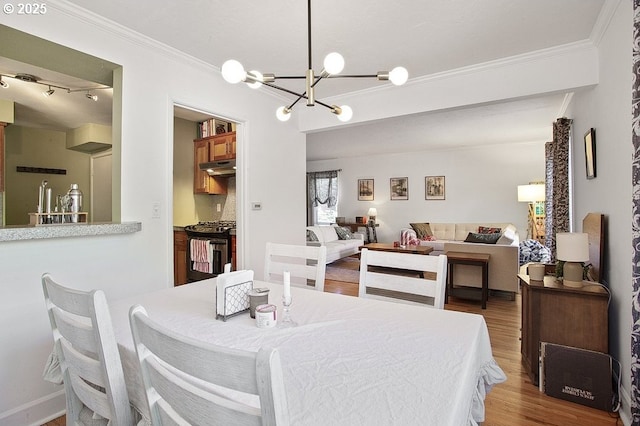 dining space featuring a chandelier, hardwood / wood-style floors, and crown molding