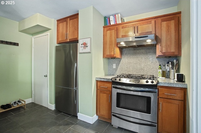 kitchen with decorative backsplash, stainless steel appliances, and dark tile patterned flooring