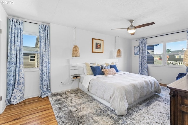 bedroom featuring ceiling fan, a textured ceiling, and hardwood / wood-style flooring