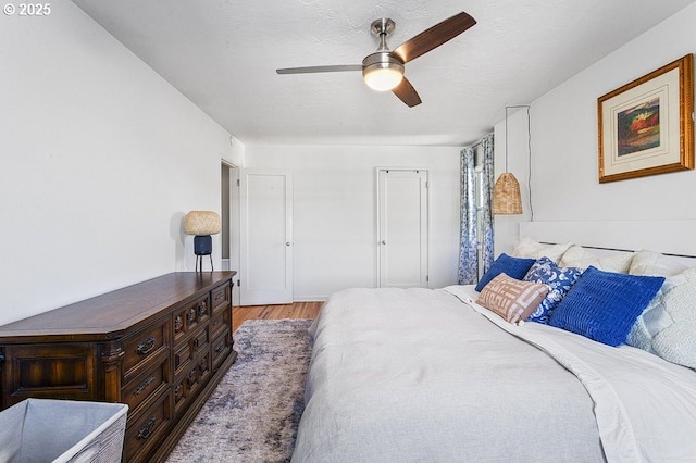 bedroom featuring ceiling fan, a textured ceiling, and light hardwood / wood-style flooring