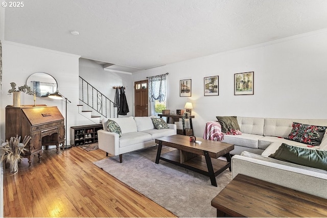 living room with a textured ceiling, light hardwood / wood-style flooring, and ornamental molding