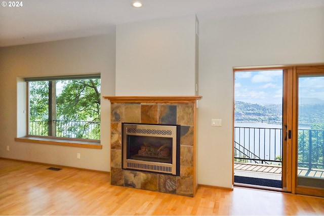 unfurnished living room with a fireplace and light hardwood / wood-style floors