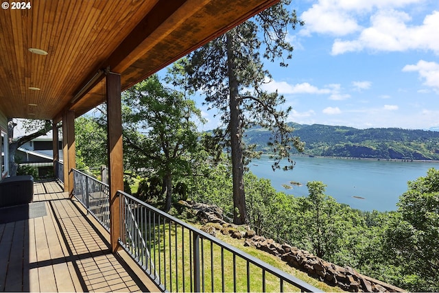 wooden terrace featuring a water and mountain view