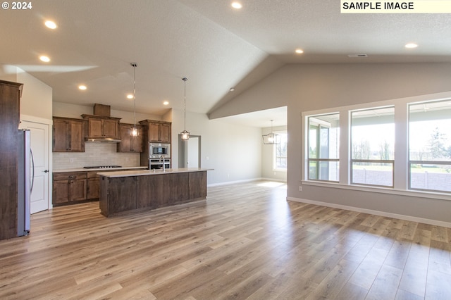 kitchen featuring a wealth of natural light, a center island with sink, and light hardwood / wood-style flooring