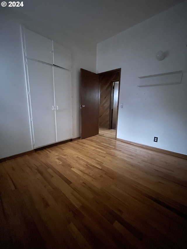 unfurnished bedroom featuring hardwood / wood-style floors and a closet