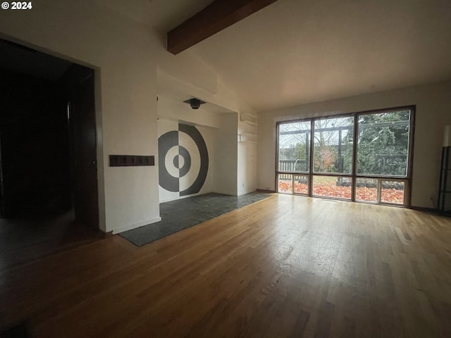 unfurnished living room featuring vaulted ceiling with beams and dark wood-type flooring