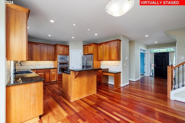 kitchen with a kitchen island, stainless steel appliances, dark hardwood / wood-style floors, and sink