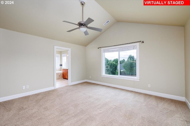 unfurnished room featuring light colored carpet, lofted ceiling, and ceiling fan