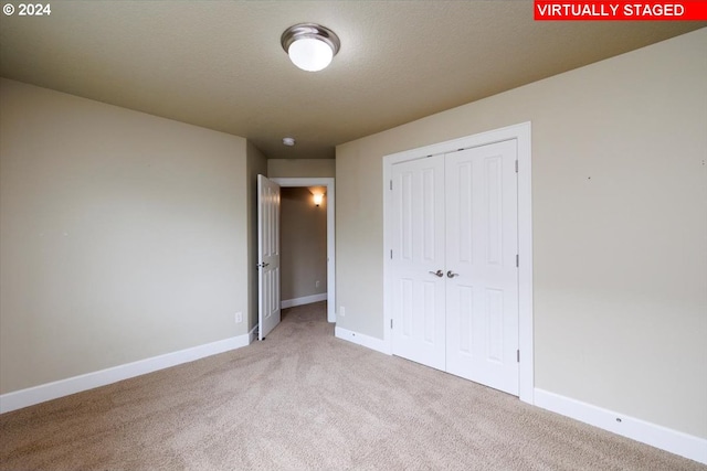 unfurnished bedroom with carpet flooring and a closet