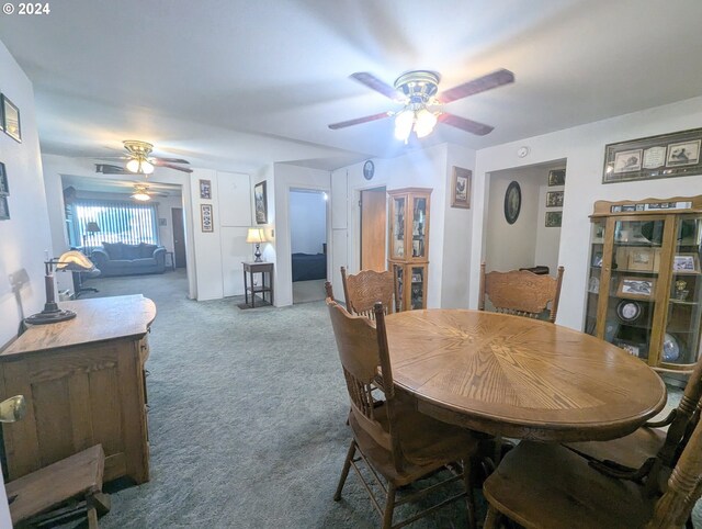 carpeted dining space with ceiling fan