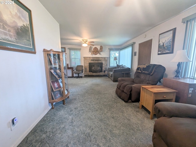 living room featuring ceiling fan, carpet flooring, and a stone fireplace