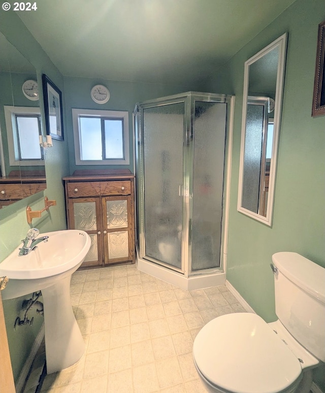 bathroom featuring toilet, tile patterned flooring, and an enclosed shower