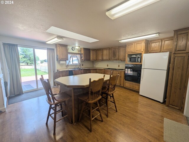 dining area featuring hardwood / wood-style floors, sink, and a textured ceiling