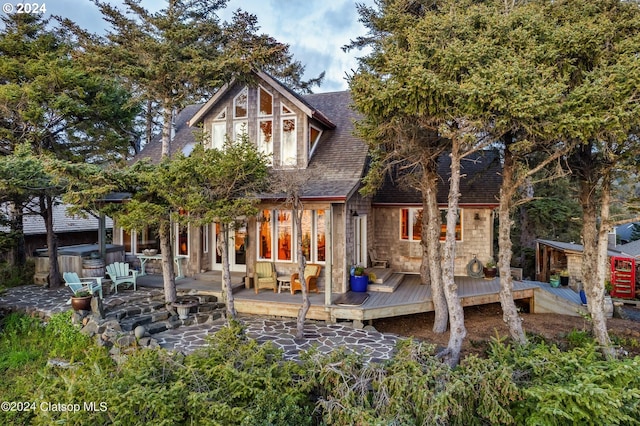 back of property featuring a hot tub and a wooden deck