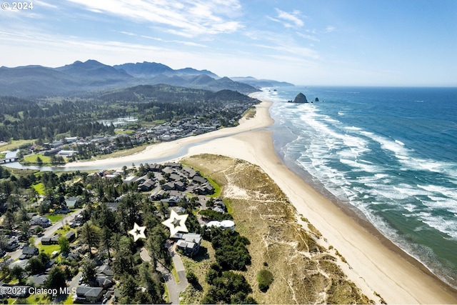 drone / aerial view with a water and mountain view and a beach view