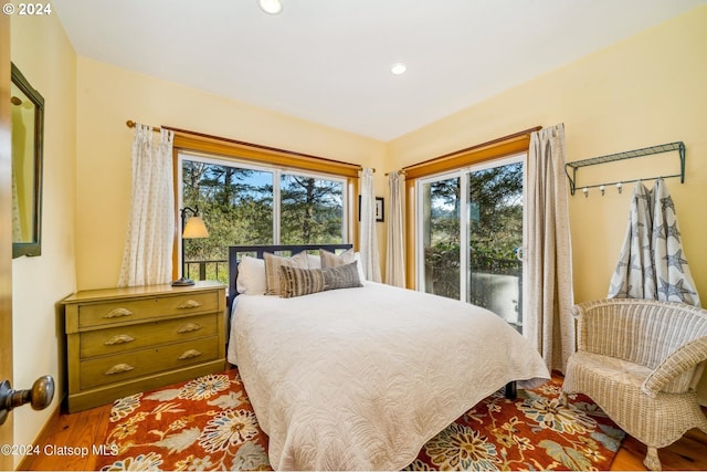 bedroom featuring wood-type flooring and access to exterior