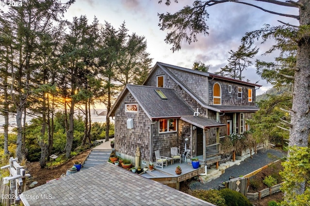 back house at dusk with a deck