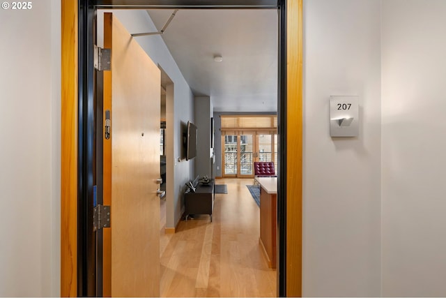 corridor with light wood-type flooring and a wall of windows