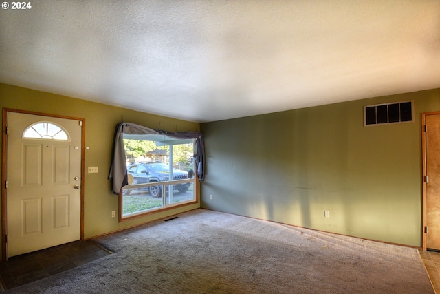 carpeted entryway featuring a textured ceiling and a healthy amount of sunlight