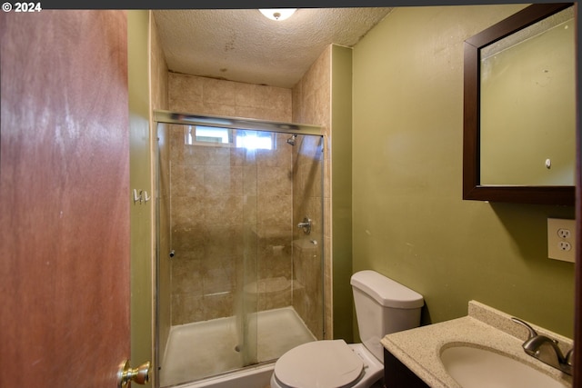 bathroom with vanity, a textured ceiling, an enclosed shower, and toilet