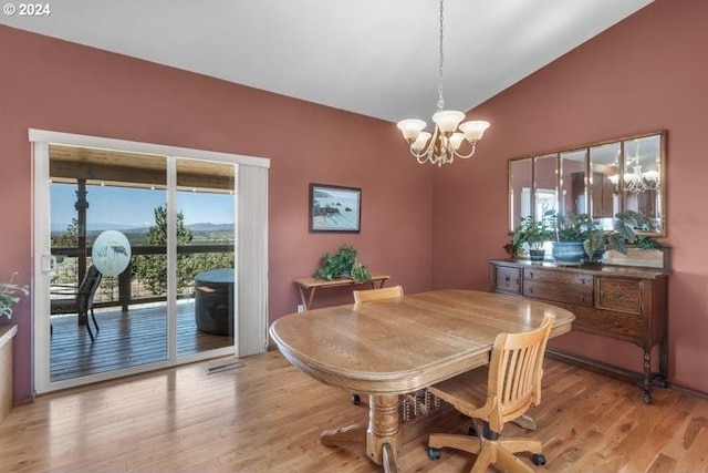 dining room featuring a notable chandelier, lofted ceiling, plenty of natural light, and wood-type flooring