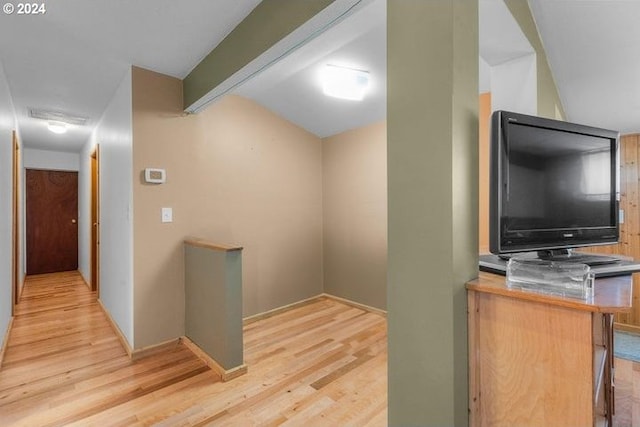 hall with beam ceiling and light hardwood / wood-style floors