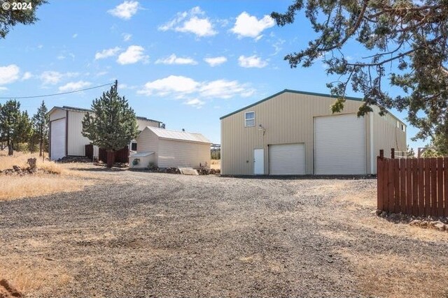 view of side of home featuring a garage and an outdoor structure