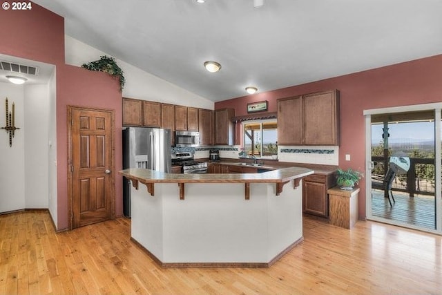 kitchen featuring a center island, range, lofted ceiling, and light hardwood / wood-style floors