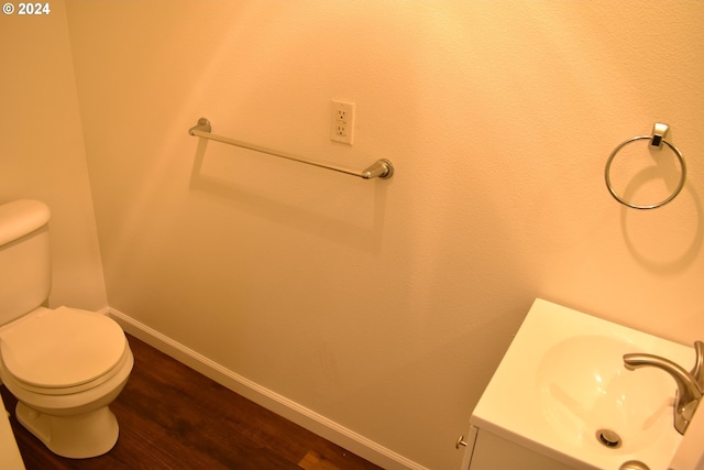 bathroom with vanity, toilet, and wood-type flooring