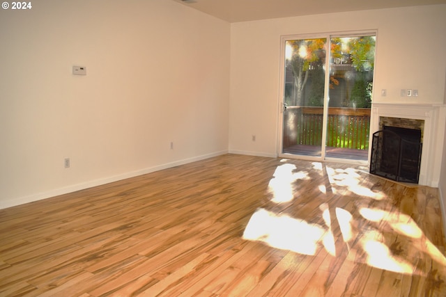 unfurnished living room featuring a fireplace and light hardwood / wood-style floors