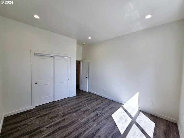 unfurnished bedroom featuring dark hardwood / wood-style floors and a closet