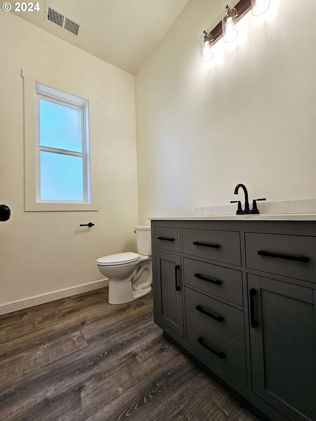 bathroom with toilet, vanity, and hardwood / wood-style flooring