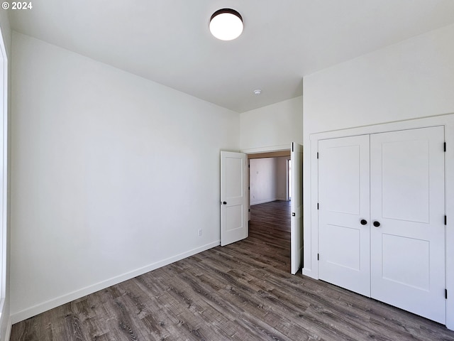 unfurnished bedroom featuring dark wood-type flooring and a closet