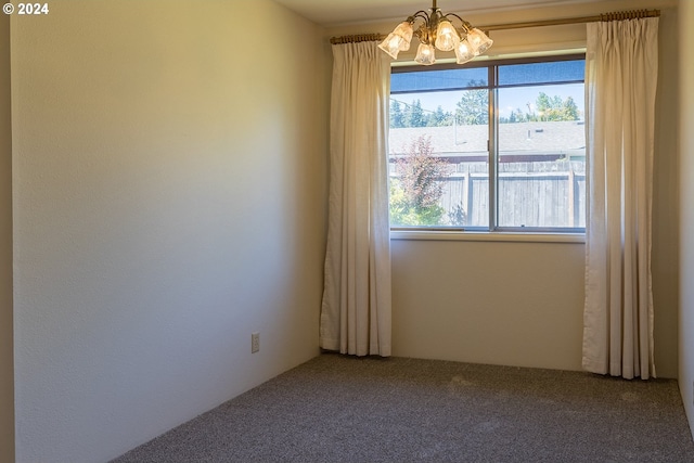 unfurnished room featuring carpet flooring, plenty of natural light, and an inviting chandelier