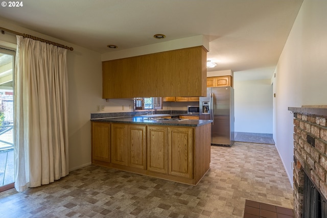 kitchen with kitchen peninsula, stainless steel appliances, a healthy amount of sunlight, and sink