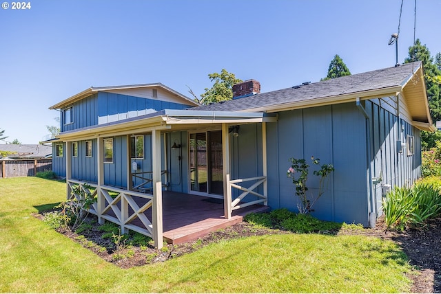 back of property featuring a yard and a wooden deck