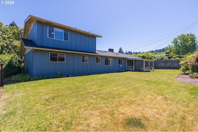 back of property with a lawn and a sunroom