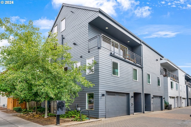 view of property exterior with a balcony and a garage