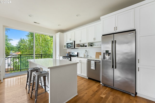 kitchen featuring white cabinetry, appliances with stainless steel finishes, hardwood / wood-style flooring, and a wealth of natural light