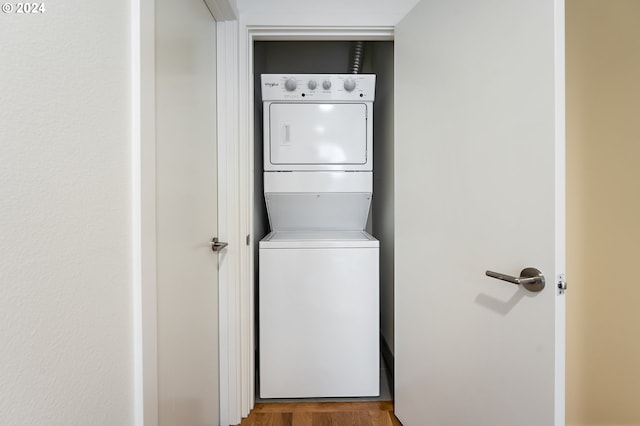 laundry area featuring stacked washing maching and dryer and hardwood / wood-style floors