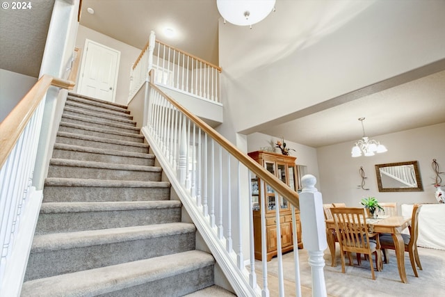 stairs featuring a chandelier and light colored carpet