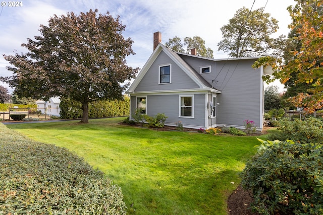 rear view of property featuring a lawn