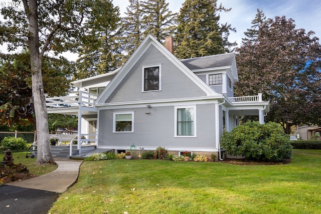 view of front of home with a front yard and a balcony