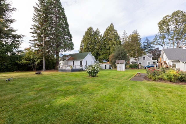 view of yard with a wooden deck and a storage shed