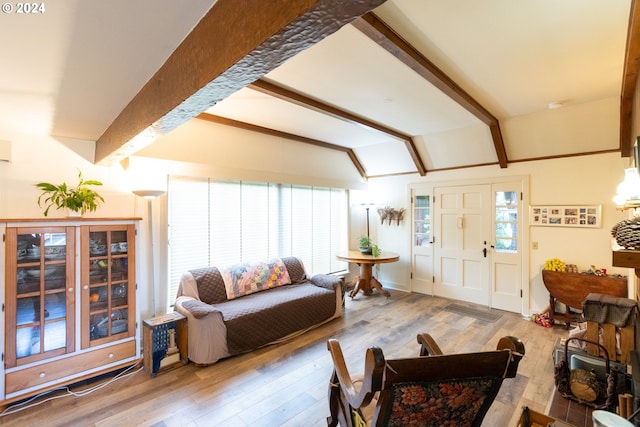 living room featuring lofted ceiling with beams, wood-type flooring, and plenty of natural light