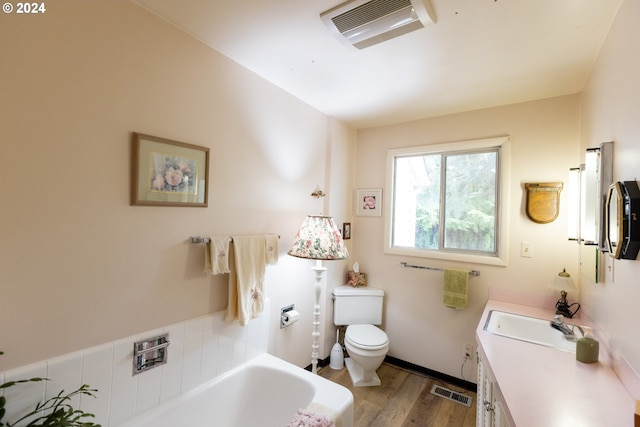 bathroom with vanity, toilet, hardwood / wood-style flooring, and a bathtub