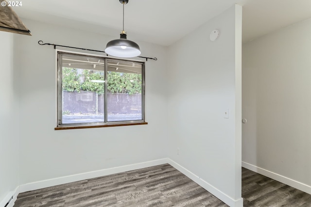 unfurnished dining area with a baseboard radiator and dark wood-type flooring