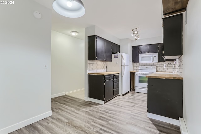 kitchen featuring butcher block countertops, sink, backsplash, white appliances, and light hardwood / wood-style flooring