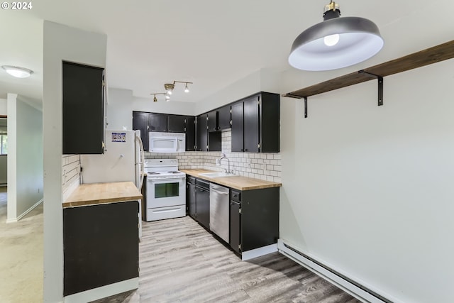 kitchen with sink, butcher block countertops, a baseboard radiator, white appliances, and decorative backsplash