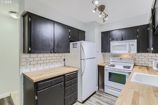 kitchen featuring tasteful backsplash, butcher block counters, and white appliances